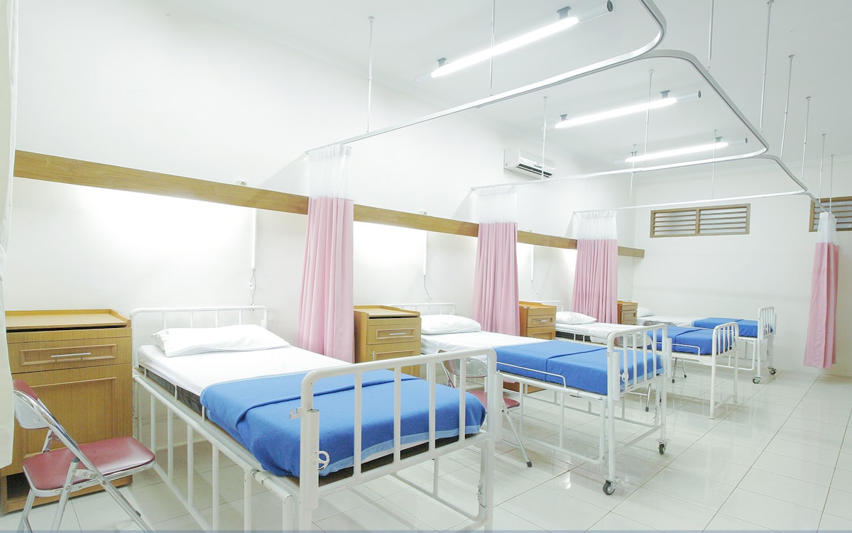 Modern hospital corridor with overhead lighting and clean architectural lines.