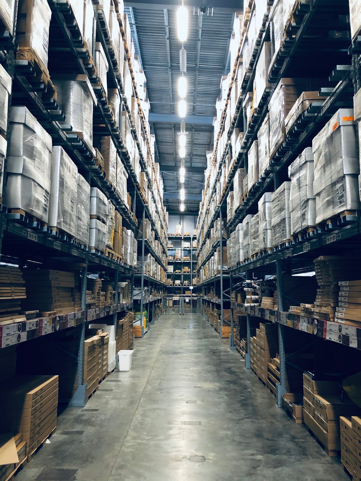 Brightly lit warehouse with shelves of inventory and workers.