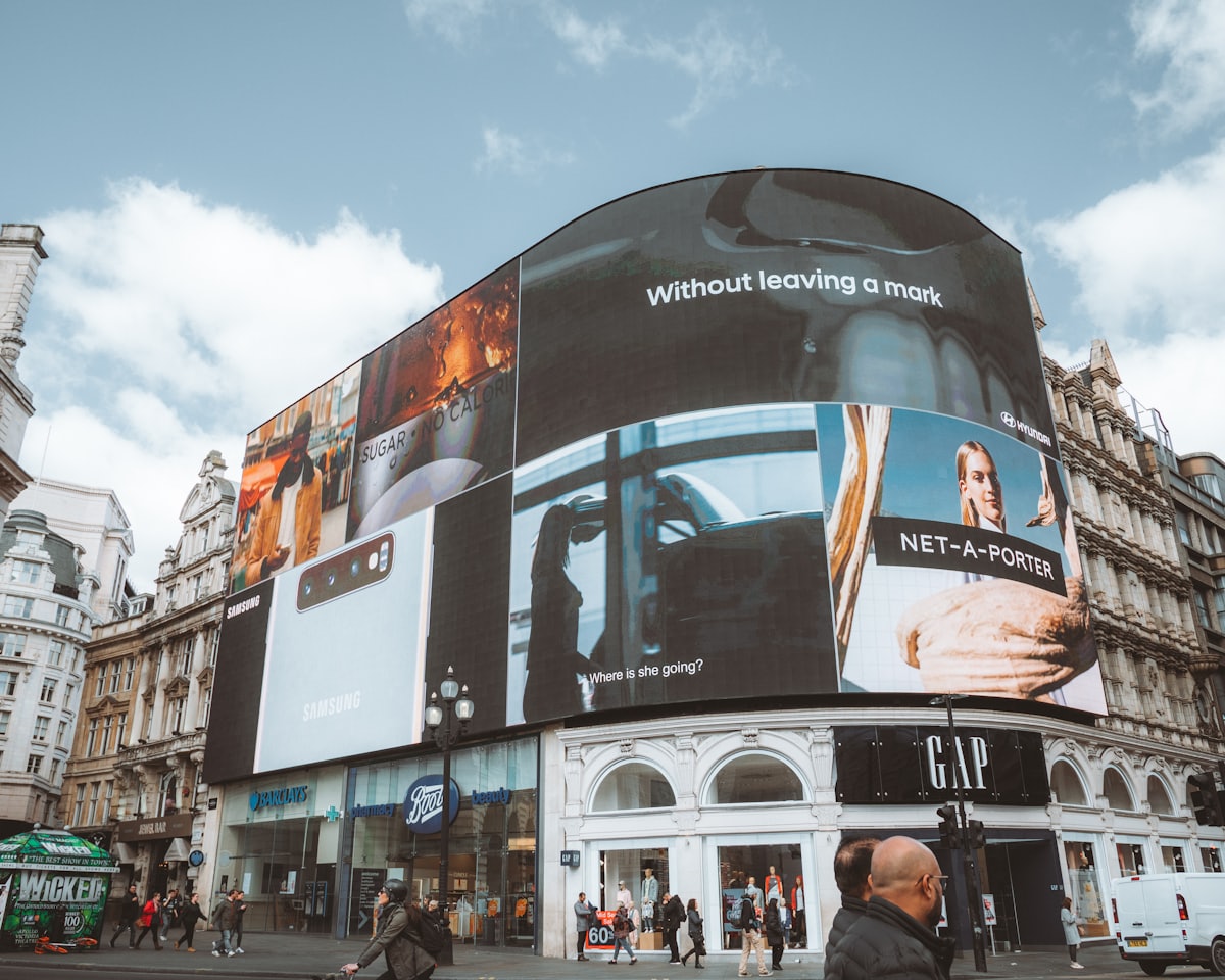 Large curved facade covered with massive illuminated LED billboards and digital signage.
