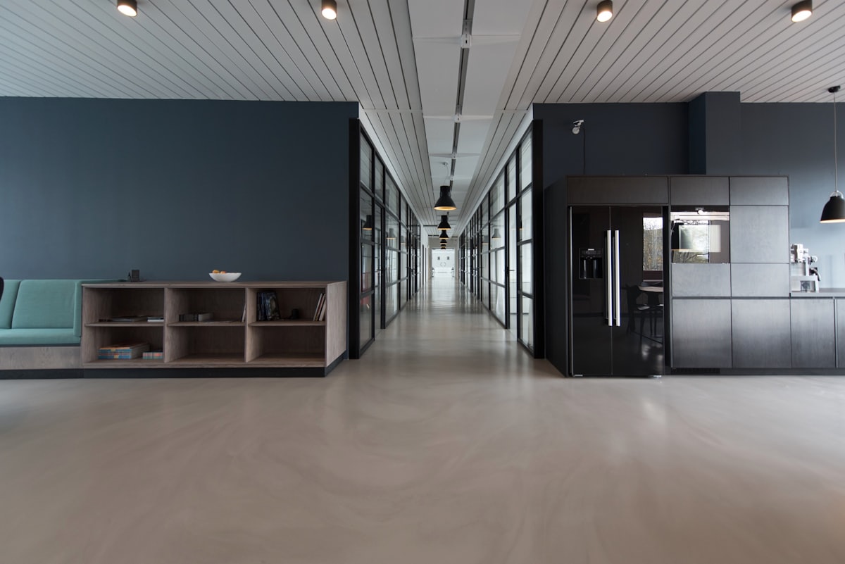 Modern open-plan office interior with workstations and screens.